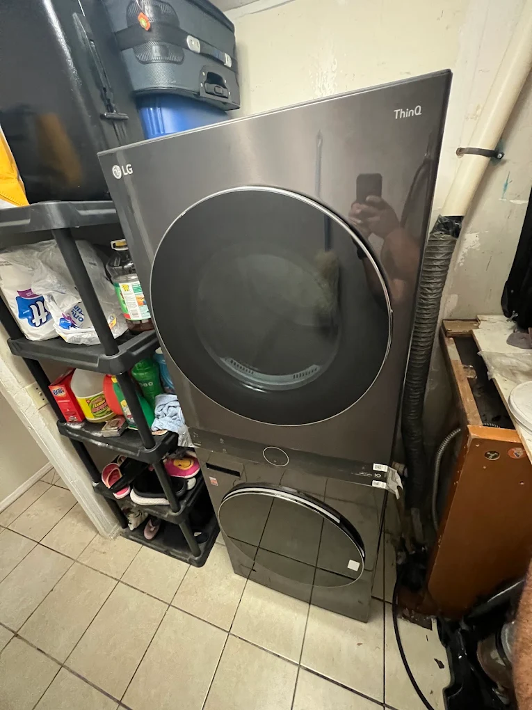Torre de lavado LG oscura instalada junto a estantes de almacenamiento