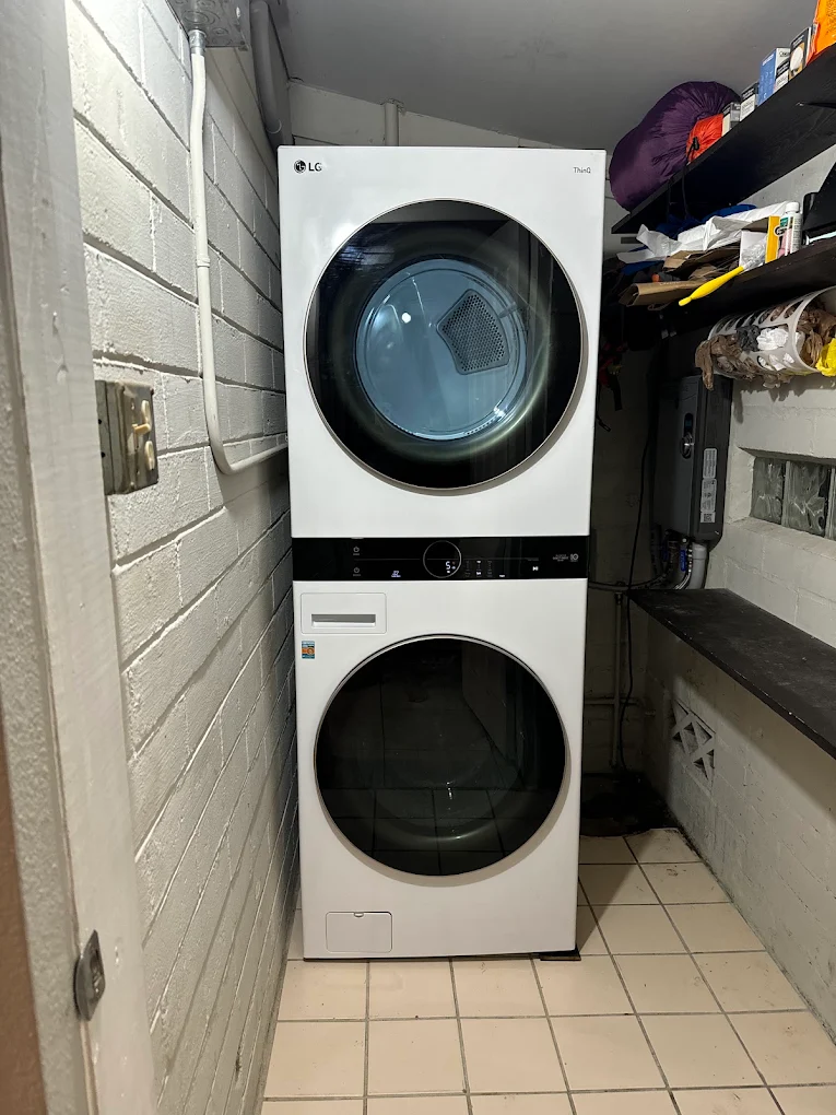 Torre de lavado LG blanca instalada en un cuarto de lavado estrecho